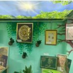 فضای نمایشی هنری درون مدرسه با تابلوهای فارسی و آثار متنوع روی دیوارهای سبز رنگ