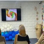 دانش‌آموزان در کلاس درس مجهز به صفحه‌نمایش و وسایل آموزشی رنگی برای فعالیت‌های تعاملی
