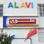 نمای بیرونی مدرسه علوی با تابلوی ورودی حاوی نام و نشان مدرسه
