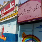 درب ورودی اصلی مدرسه علوی میدان اعظم تهران با تابلوی نام مدرسه و دیزاین دیوار رنگی‌شده