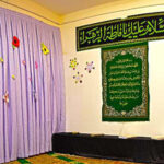 نمازخانه مدرسه مجهز به سجاده و کتیبه‌های قرآنی با تزیینات اسلامی