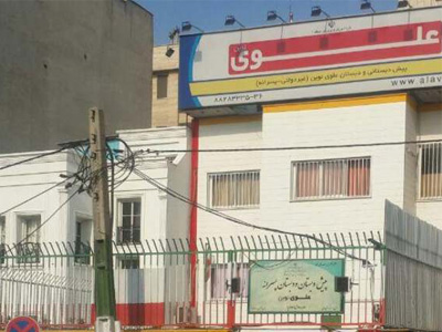 نمای بیرونی ساختمان دبستان علوی نوین با تابلوی مدرسه