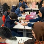 دانش‌آموزان در حال انجام فعالیت هنری و نقاشی در کلاس درس با استفاده از مواد خلاقانه و جنس‌های تزئینی