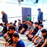دانش‌آموزان مدرسه در حال نماز جماعت در نمازخانه، در حالی‌های مختلف رکوع و سجود