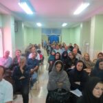 تجمع والدین و اعضای کادر درسی مدرسه در یک جلسه گروهی در سالن درون‌ساختمانی
