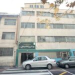 نمای بیرونی درب ورودی مدرسه درنیانه‌سازان الامه الطباطبائی با تابلوی دائمی سبز رنگ و ساختمان مدرسه