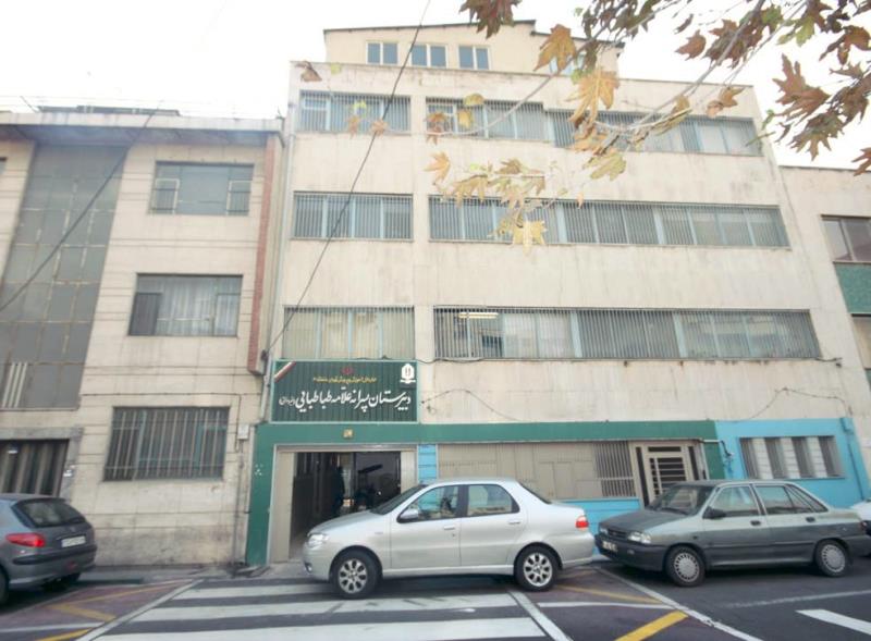 نمای بیرونی درب ورودی مدرسه درنیانه‌سازان الامه الطباطبائی با تابلوی دائمی سبز رنگ و ساختمان مدرسه