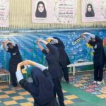 دانش‌آموزان دختری در حیاط مدرسه در حال انجام فعالیت حرکات بدنی و ورزش جمعی تحت نظارت
