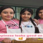 دانش‌آموزان دختر در حال انجام فعالیت آشپزی و پخت‌وپز با آپرون و تجهیزات آشپزخانه مدرسه