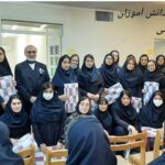 گروهی از دانش‌آموزان و معلمان در یک مراسم تقدیری، دانش‌آموزان با بروشور و گواهینامه در حالی که برای عکس گروهی اجتماع کرده‌اند