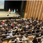 تالار اجتماعات مدرسه با حضور گسترده دانش‌آموزان و کادر اداری در یک برنامه رسمی