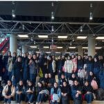 جمع‌آوری دانش‌آموزان و معلمان در سالن بزرگ مدرسه برای یک رویداد یا مراسم اجتماعی