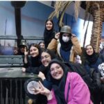 دانش‌آموزان در حال شرکت در فعالیت نمایشگاهی تاریخی با خودروی قدیمی نظامی