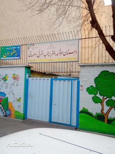 درب ورودی دبستان دخترانه اشرفی اصفهانی با نقاشی دیواری رنگارنگ و تابلوی نام مدرسه
