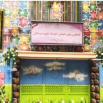نمای ورودی و سردر دبستان و پیش‌دبستان درخت آوای پسیبانیان با درب‌های سبز رنگ، تابلوی نام مدرسه، و تزئینات رنگی