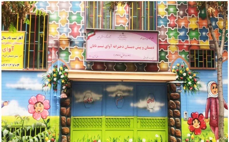 نمای ورودی و سردر دبستان و پیش‌دبستان درخت آوای پسیبانیان با درب‌های سبز رنگ، تابلوی نام مدرسه، و تزئینات رنگی