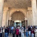 گروهی از دانش‌آموزان در حال ایستادن جلوی درب ورودی مدرسه برای عکس یادی