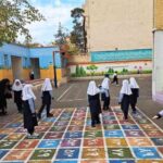 دانش‌آموزان در حیاط مدرسه روی پیاده‌روی کاشی‌دار رنگارنگ