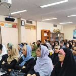 دانش‌آموزان دختر در کلاس درسی مجهز به تخته سیاه، تابلو نوشتافزار و پروژکتور سقفی