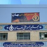 نمای بیرونی ساختمان مدرسه با سردرهای دائمی و تابلوهای آزرفش