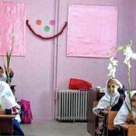 دانش‌آموزان در حال مشارکت در فعالیت خلاق با گل‌های رنگین داخل کلاس درس