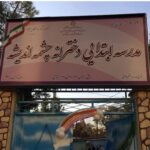 تابلوی ورودی مدرسه با نام‌نویسی فارسی و نشان ملی بر روی درب رنگی با تزئینات هندسی