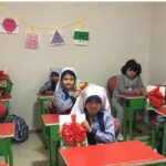 دانش‌آموزان در کلاس درس حین برگزاری مراسمی وطنی با پرچم‌های قرمز و سفید ایران