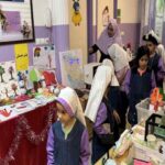 دانش‌آموزان در حین شرکت در نمایشگاه پروژه‌های آموزشی داخل کلاس درس با تزئینات و آثار هنری دیواری