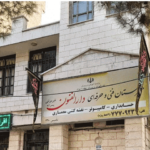 نمای بیرونی ساختمان مدرسه داراً‌الفنون با سردر، تابلوی دائمی اطلاعات موسسه و تزیینات ملی