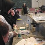 دانش‌آموزان دختر در حال انجام فعالیت آزمایشی شیمیایی با وسایل آزمایشگاهی در کلاس درس