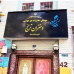 نمای بیرونی درب ورودی دبستان دخترانه درشرق با تابلوی مشکی و متن طلایی