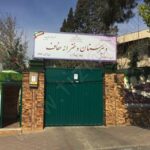 درب ورودی و سردر مدرسه با نمای ساختمان آجری و دروازه سبز