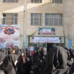 تجمع دانش‌آموزان دختر مدرسه امام باقر در جلوی درب ورودی ساختمان برای حضور در مراسم یا رویداد مدرسه‌ای