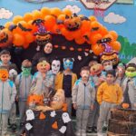 دانش‌آموزان مدرسه با گریم و لباس هالووین درحال برپایی مراسم و جشن هالووین در محوطه‌ی درون ساختمان