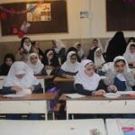 نمای داخلی کلاس درس با دانش‌آموزان نشسته پشت میز‌های درسی