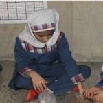 دو دانش‌آموز دختر در حین انجام یک فعالیت تعاونی/بازی آموزشی درون کلاس درس