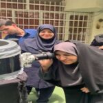دانش‌آموزان دختری در حال انجام آزمایش علمی گروهی با ابزارهای آزمایشگاهی و میکروسکوپ