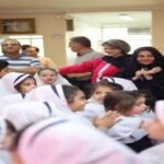 گرد‌هم‌آیی معلمان و دانش‌آموزان در حین برگزاری یک مراسم یا جشن در محیط داخلی مدرسه