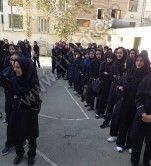 دانش‌آموزان دختر پوشیده به فرم مشکی در حال حضور در مراسم صبحگاهی مدرسه