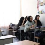 دانش‌آموزانی در حال شرکت در فعالیت درسی تعاملی در کلاس با معلم و یکدیگر