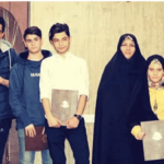 گروهی از دانش‌آموزان و معلمان در یک مراسم رسمی مدرسه‌ای با کتاب‌های ارائه‌شده یا تقدیری