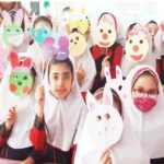 دانش‌آموزان با ماسک‌های رنگی دستساخته در حال شرکت در یک فعالیت هنری و خلاقانه در کلاس درس