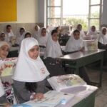 دانش‌آموزان دختر در کلاس درس در حال انجام فعالیت مطالعه و خواندن مطبوعات و مواد آموزشی
