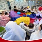 دانش‌آموزان در حال شرکت در فعالیت گروهی با پارچه‌های رنگین در کلاس درس