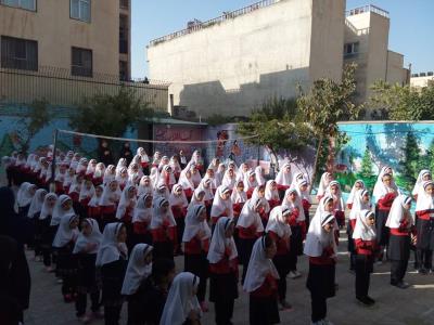 دانش‌آموزان مدرسه در حال شرکت در یک مراسم و گردهمایی منظم در حیاط مدرسه