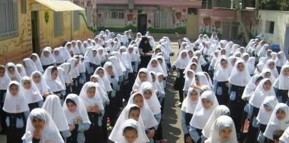 دانش‌آموزان دختر در حال نماز جماعتی در حیاط مدرسه