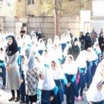 گردهمایی دانش‌آموزان دختر و پسر با پوشش مدرسه در حیاط برای یک مراسم یا رویداد دانش‌آموزی