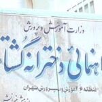 تابلوی نمایش نام دبیرستان شهید چهریت در ورودی ساختمان با متن‌های فارسی