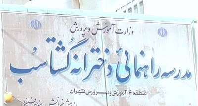 تابلوی نمایش نام دبیرستان شهید چهریت در ورودی ساختمان با متن‌های فارسی