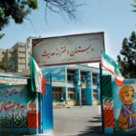 نمای بیرونی ورودی اصلی دبستان و دبیرستان هادی شریف با تابلوی نام مدرسه، دیوار رنگی آبی و نقاشی شاد کودکان، درهای آبی و پرچم‌های ایرانی